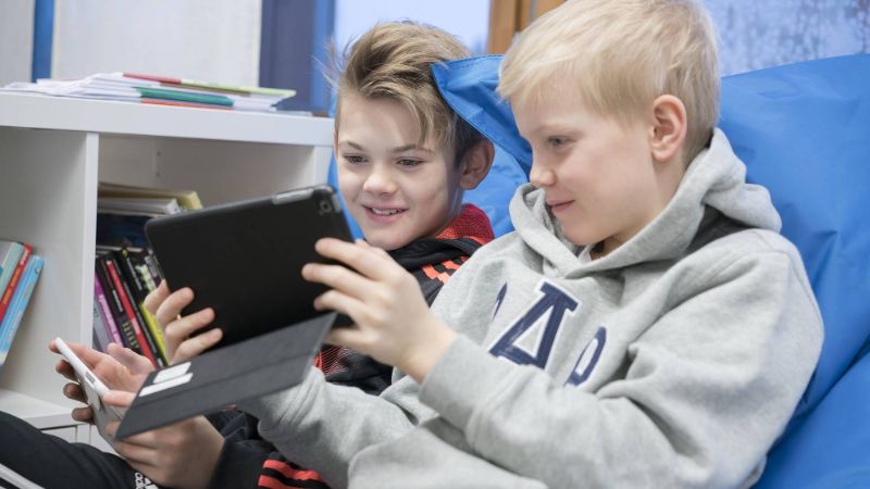 Two boys looking at a tablet screen